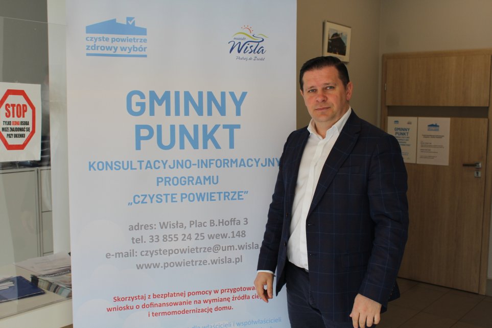 Burmistrz miasta na tle baneru promocyjnego programu